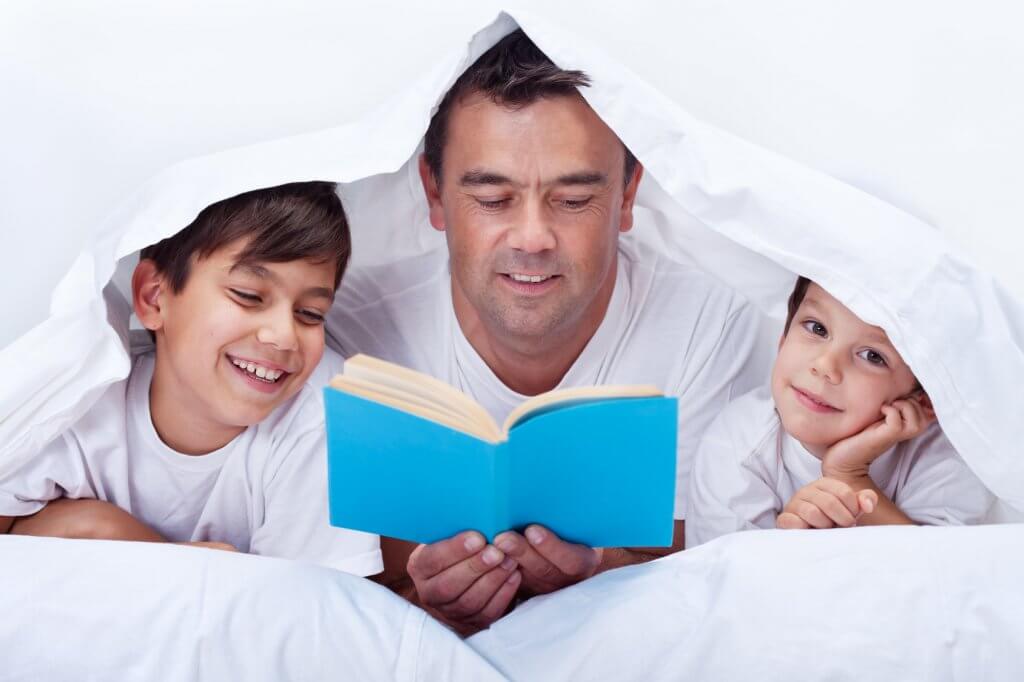 Père qui lit une histoire avec ses garçons.
